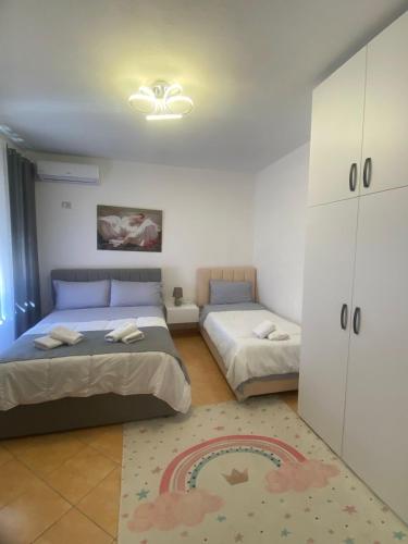 sypialnia z dwoma łóżkami, szafką i dywanikiem w obiekcie Hamide's Apartment w Durrës