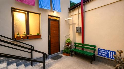 a green bench sitting in front of a building at Paata's Guesthouse in Borjomi