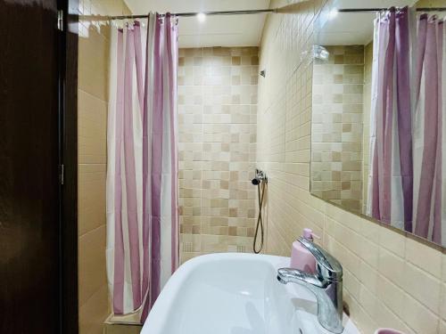 a bathroom with a sink and a pink shower curtain at Appartement Climatisé 2 Chambres à Marrakech Proche Golf & Jamaâ El Fna in Marrakesh