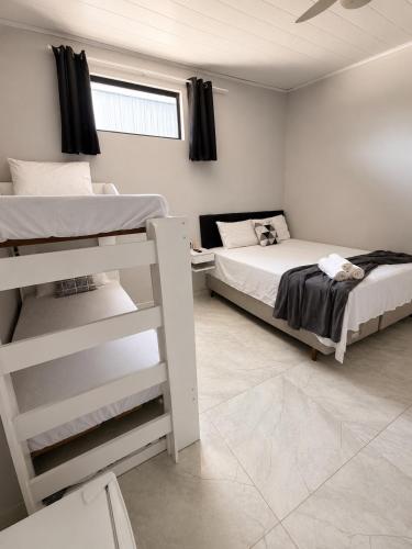 a bedroom with two bunk beds and a window at Brisamar Suítes Ilha Grande in Angra dos Reis