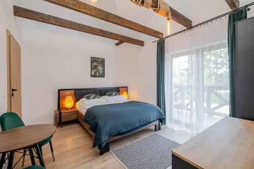 a bedroom with a bed and a table and a window at Rezydencja nad rzeką in Łeba