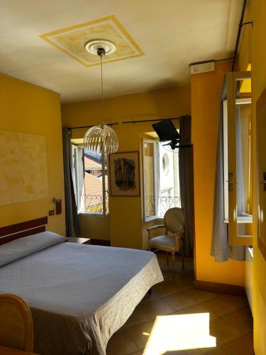 a bedroom with a bed and a chandelier at Hotel Spagna in Arona