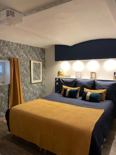 a bedroom with a large bed with a yellow blanket at Entre Nous - La Poste in Saumur