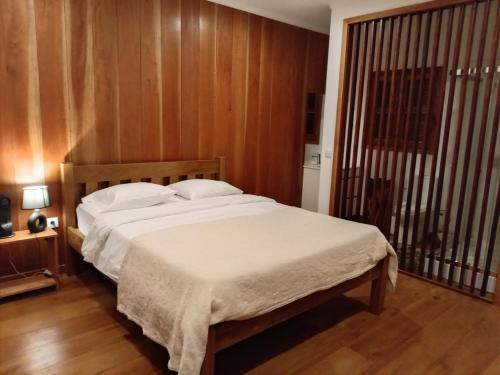 a bedroom with a large bed with white sheets at Casa Augusto Stunning view in Trindade