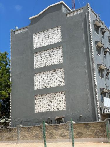 a tall gray building with a fence in front of it at Kilifi Studio in Kilifi