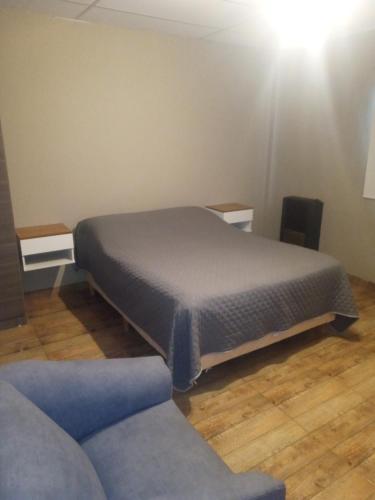 a bedroom with a bed and a couch in a room at Apart Trelew 3 in Trelew