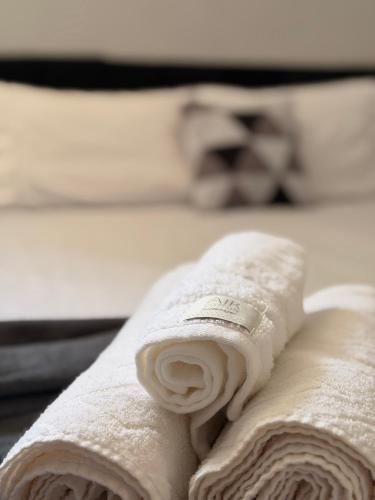 a roll of white towels sitting on top of a bed at Brisamar Suítes Ilha Grande in Angra dos Reis