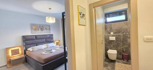 a bedroom with a bed and a bathroom with a shower at Villa Kajgo-Pag in Pag