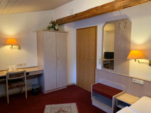 a room with a desk and a cabinet and a mirror at Zum Flößer in Neckartenzlingen