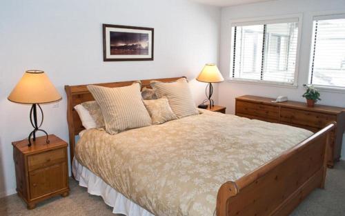 a bedroom with a bed with two lamps and two windows at Dollar Meadows #1373 in Sun Valley