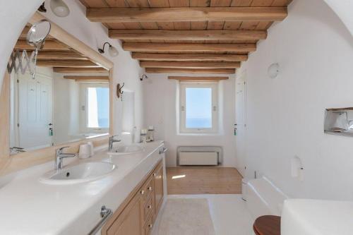 a bathroom with two sinks and a large mirror at Cozy Villa in Mykonos