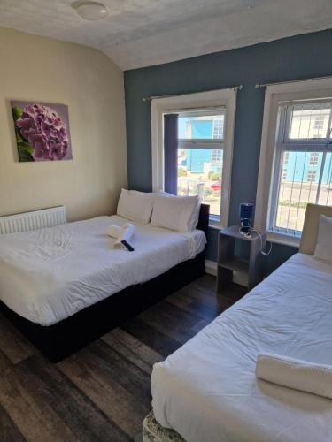 a hotel room with two beds and two windows at South Cliff Hotel in Blackpool