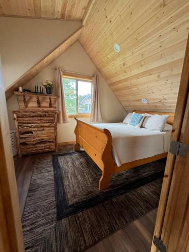 a bedroom with a bed and a wooden ceiling at Homer Spit View Cabins - The Log Cabin in Homer