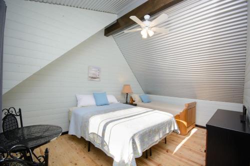 a bedroom with a bed and a ceiling fan at Homer Spit View Cabins - The Cottage in Homer