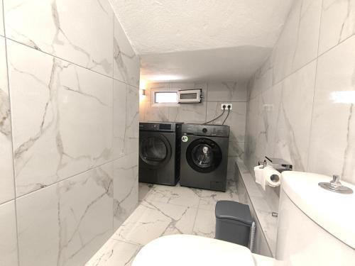 a bathroom with a washer and dryer in it at Rael Apartments - free Parking in Katerini