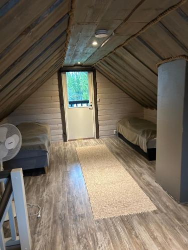 ein Zimmer mit zwei Betten und einer Tür in der Unterkunft Kärrända in Nedervetil
