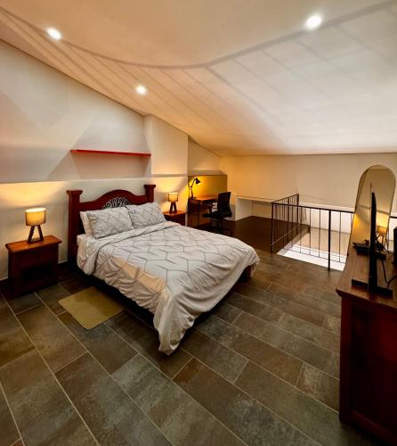a bedroom with a large bed and a staircase at Apartamentos Chia in Chía
