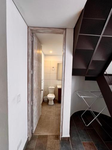 a small bathroom with a toilet and a staircase at Apartamentos Chia in Chía