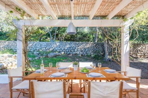 a dining room with a wooden table and chairs at Finca Ses Curtanetas by 3VILLAS in Alaior