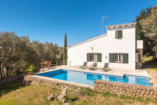 a villa with a swimming pool in front of a house at Finca Ses Curtanetas by 3VILLAS in Alaior