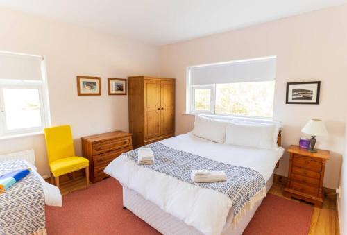 a bedroom with a bed and a yellow chair at Tri Phailme in Waterville