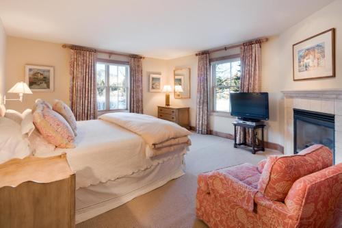 - une chambre avec un lit, une télévision et une cheminée dans l'établissement Harriman Cottage at Sun Valley, à Sun Valley