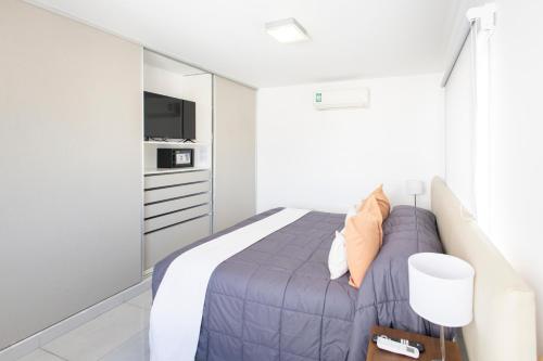 a bedroom with a bed and a tv at HOMEFULL Apartamentos in Salta