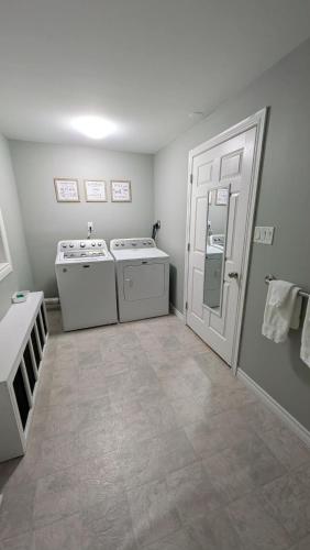 a laundry room with two washes and a door at spacious three bedroom apartment in Bras D'or