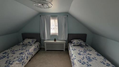 a attic bedroom with two beds and a window at spacious three bedroom apartment in Bras D'or