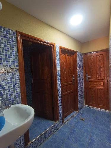 a bathroom with wooden doors and a sink in it at Toubkal Guesthouse in Imlil