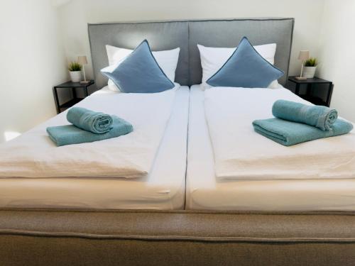 a large bed with blue pillows on it at Ferienwohnung Sternblick im Allgäu nahe Fendt in Marktoberdorf