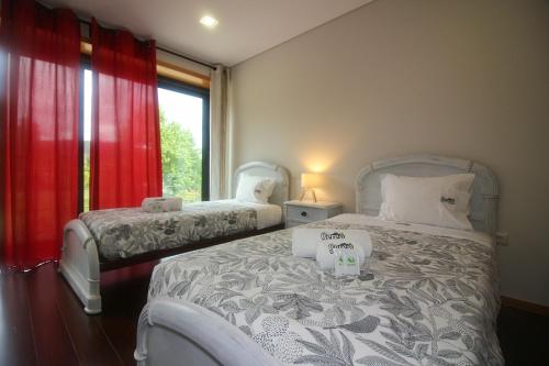a bedroom with two beds and a window at Villa Travessa das Lages in Vieira do Minho