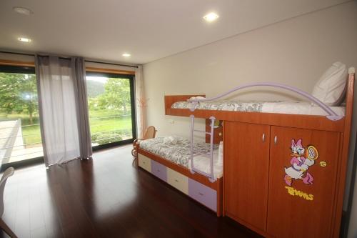 a childs bedroom with a bunk bed and a window at Villa Travessa das Lages in Vieira do Minho
