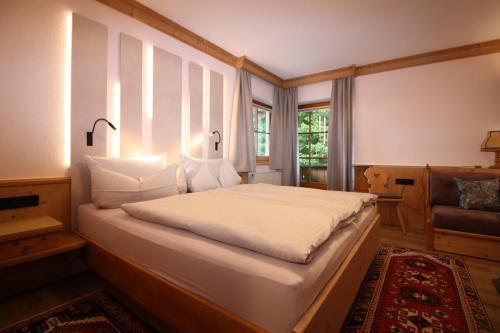 a bedroom with a large white bed with a window at Vronis Waldhaus ADULTS ONLY in Mayrhofen