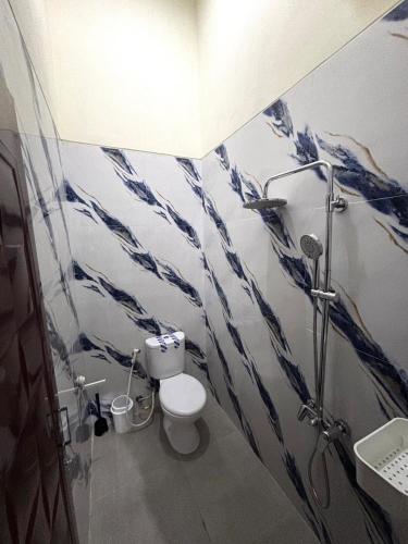 a bathroom with blue and white wallpaper with a toilet at Secretspot Yogyakarta in Yogyakarta