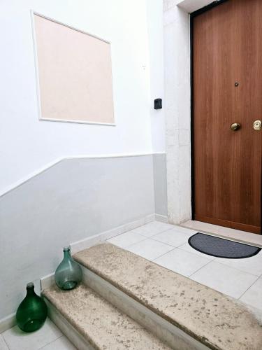 two green vases sitting on the floor next to a door at Maestrale in Giovinazzo