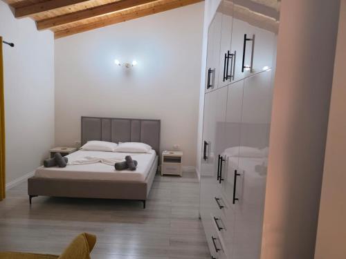 a white bedroom with a bed and a mirror at apartment Himara SkyView in Himare
