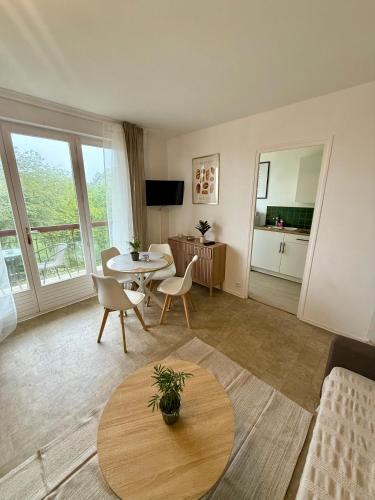 a living room with a table and a couch at Appartement moderne tout équipé in Évreux