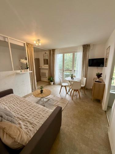 a bedroom with a bed and a table and chairs at Appartement moderne tout équipé in Évreux