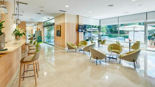 a lobby with chairs and tables and windows at Sercotel Porta Barcelona in Sant Just Desvern