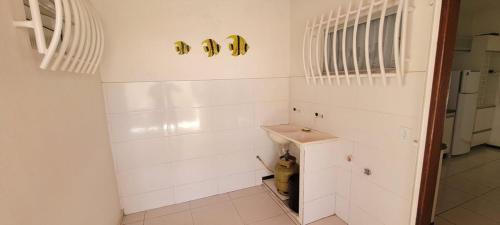a bathroom with white walls and a sink at Casa de praia em Guriri in Guriri