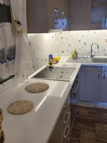 a kitchen with a counter with a stove and a sink at apartment Himara SkyView in Himare