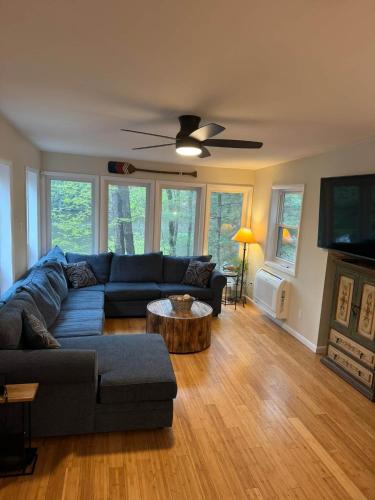 a living room with a couch and a table at Fun 5 Bedroom Lakefront Cottage in Bethel