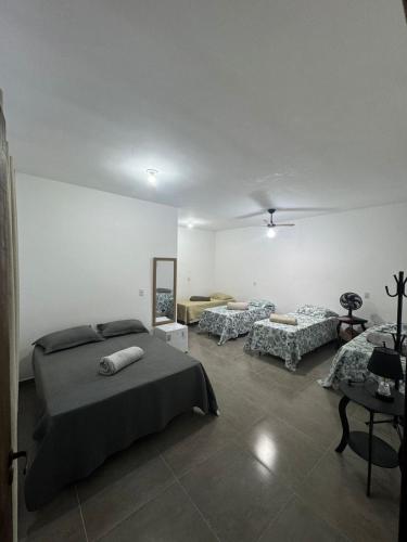 a bedroom with two beds and a mirror in it at Hotel Pousa Vale Imperial in Aparecida