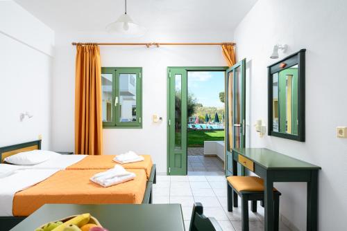 a hotel room with two beds and a desk at Nikolas Villas Appartments in Hersonissos