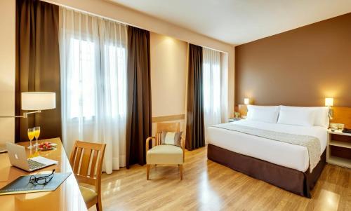 a hotel room with a bed and a desk at Sercotel Alcalá 611 in Madrid