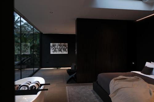 a bedroom with a bed and a bath tub next to a tub at The Ruler Bali in Penginyahan