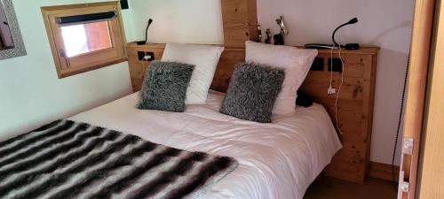 a bed with two pillows on it in a room at Portes du Soleil T3 "comme un chalet" direct access Morzine Avoriaz in Montriond