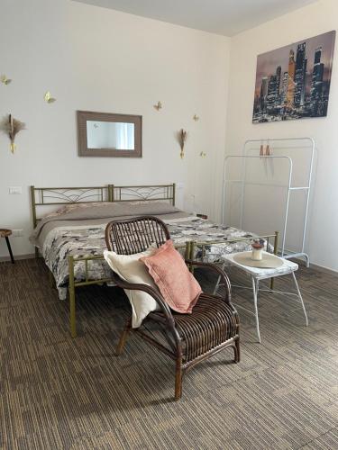 a bedroom with a bed and a chair and a table at R&B MiDora Modena in Modena