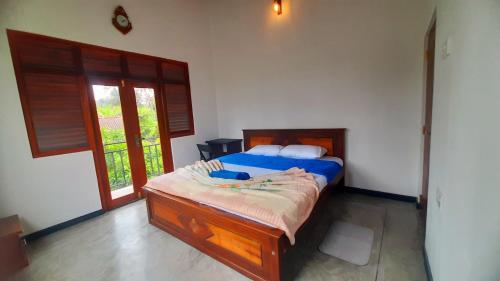 a bedroom with a bed with a blue comforter at Anchor House in Ahangama